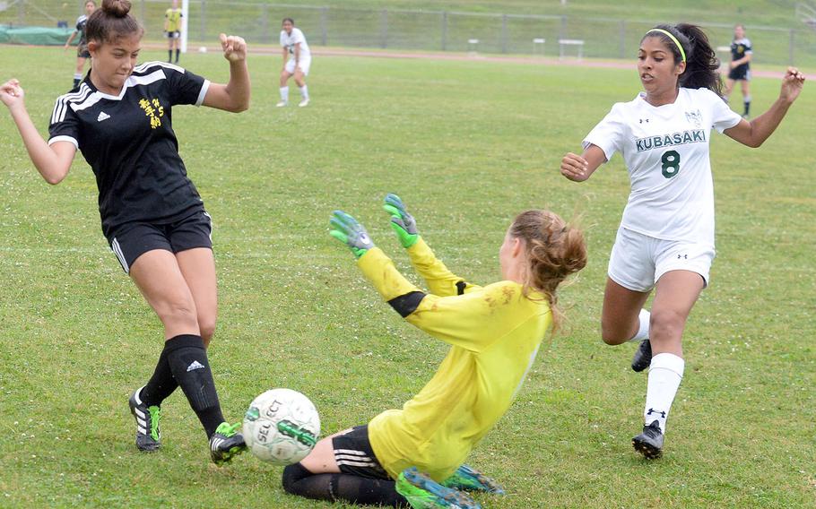 Kadena's Alexa Smith and Kubasaki goalkeeper Abbigail Irwin nearly collide after Smith sends a shot wide of the net, as Dragons' Angelica Figueroa looks on during Friday's Okinawa girls soccer match. The Panthers won 7-2 to sweep the season series.