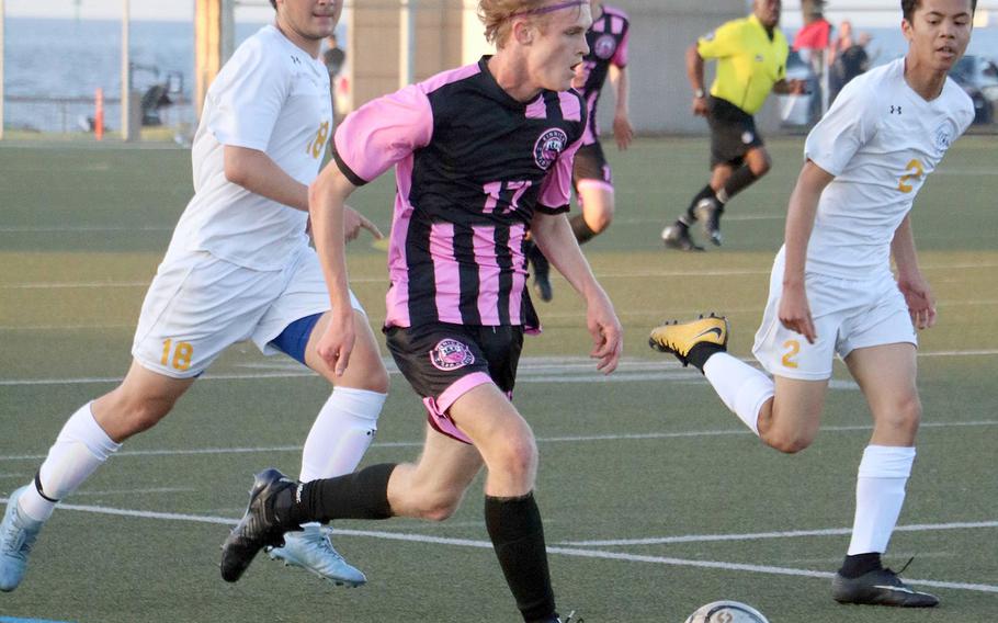 Nile C. Kinnick's Jack Boran dribbles upfield against Yokota's Andrew Beene and Justin Schneck during Friday's Japan boys soccer match. The Panthers prevailed 3-2.
