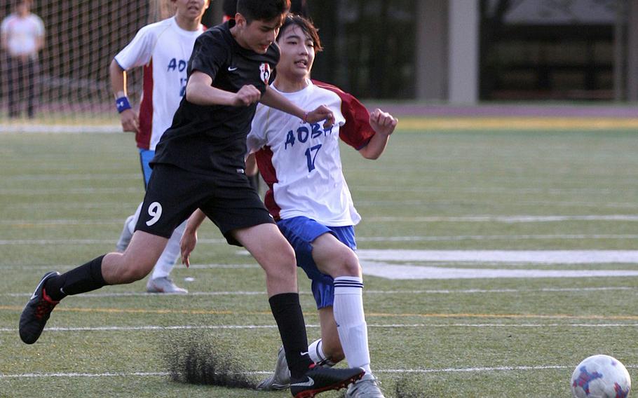 Zama's Andrew Quinteros kicks the ball away from an Aoba International opponent during Friday's Japan boys soccer match. The Trojans beat the Jaguars 4-1.