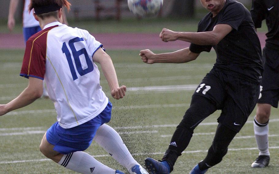Zama's Justyn Seraphin boots the ball against an Aoba International opponent during Friday's Japan boys soccer match, won by the Trojans 4-1.