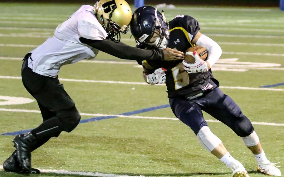 Guam High receiver Jalen Thach struggles to get free of Tiyan defensive back Jaython Cruz.