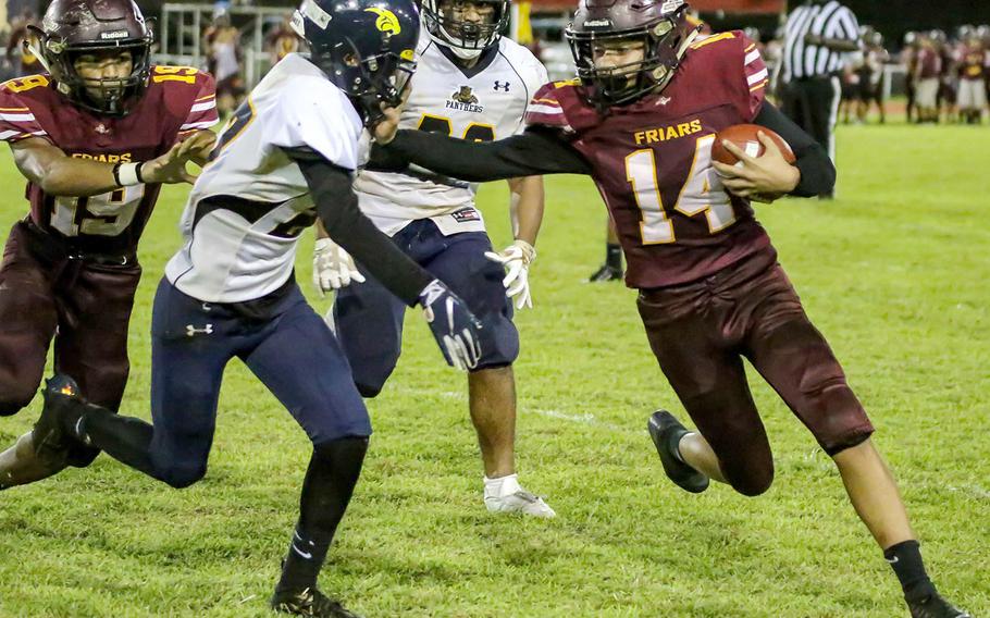 Father Duenas' William Ludwig tries to turn the corner and stiff-arms Guam High defender Gino Rameriz.