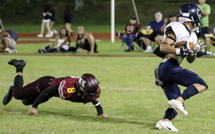 Guam High's Jalen Thach turns upfield with the ball past Father Duenas defender Nate Mendiola for one of his two touchdown catches.