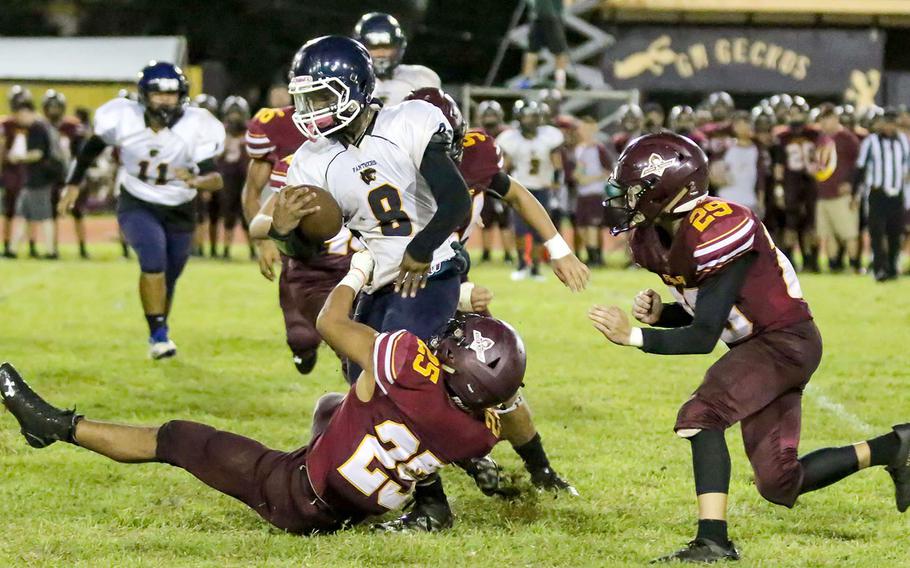 Guam High running back Jayson Jackson tries to elude the defense of Father Duenas' Gene Arriola and Kekoa Gamboa.