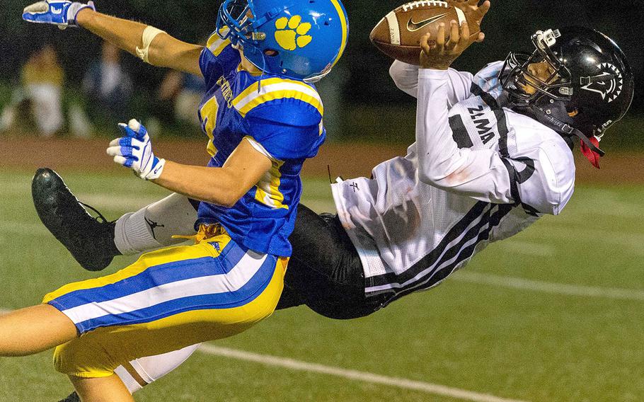 Zama's Keshawn McNeill snags a pass as he falls backwards against Yokota defender Caleb Jones.