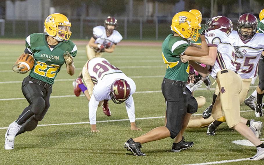 Robert D. Edgren running back Douglas Tackney rushes around right end for a first down against Matthew C. Perry.