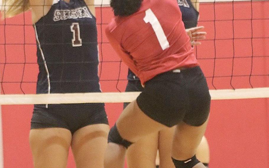 Nile C. Kinnick's Lynelle Adepoju tries to spike through the double block of Seisen's Lisa Purcell and Grace Starr during Thursday's Kanto Plain girls volleyball match, won by the Red Devils 3-2.