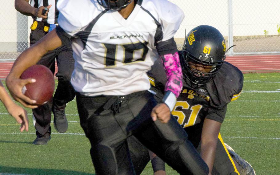 Humphreys quarterback Deontaye Gregory cuts around left end and leaves Kadena defender Cameron Copeland behind.