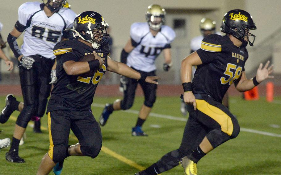 Kadena running back Alfonso Mendez follows blocker Dean Owen around right end against Humphreys.