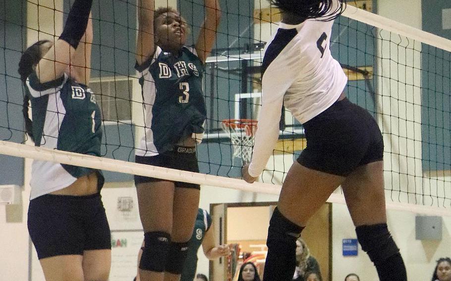 Humphreys' Jalynn Knight spikes the ball against Daegu's Hazel Bell and Ariel Harvey during Wednesday's Korea girls volleyball match, won by the Blackhawks in three sets.
