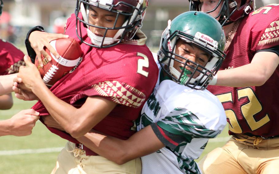 Matthew C. Perry quarterback Joel Pacleb gets wrapped up by Daegu's Jayson McCode.