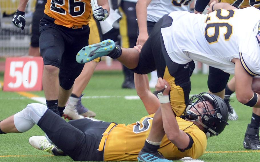 American School In Japan defender Nash Rasmussen wrestled Kadena running back Alfonso Mendez to the turf.