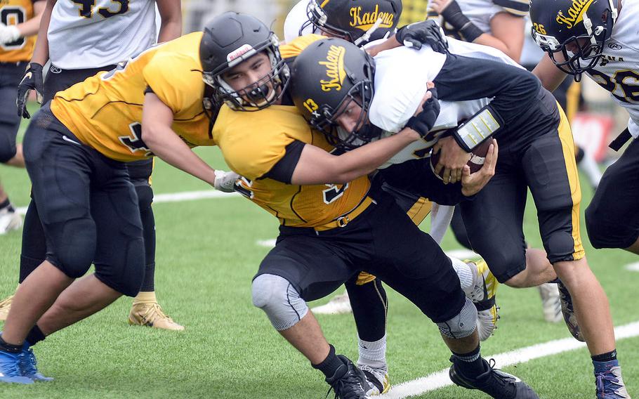 Kadena quarterback Jack Carey gets wrapped up by several American School In Japan defenders.