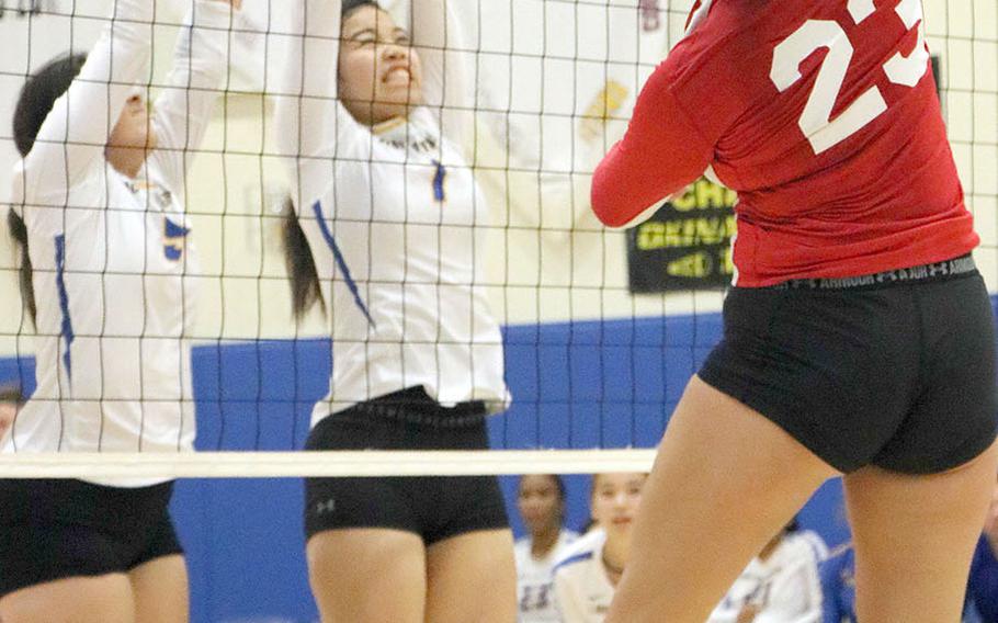Nile C. Kinnick's Madelyn Gallo spikes against Yokota defenders Ania Davis and Linna Morrow during Tuesday's DODEA-Japan/Kanto Plain girls volleyball match, won by the Red Devils in straight sets.