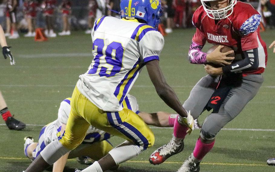 Nile C. Kinnick quarterback Patrick Kelly tries to elude Yokota defender Michael Royster.