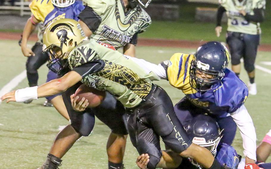 Titans running back Jude Cruz is snowed under by Guam High's defense.