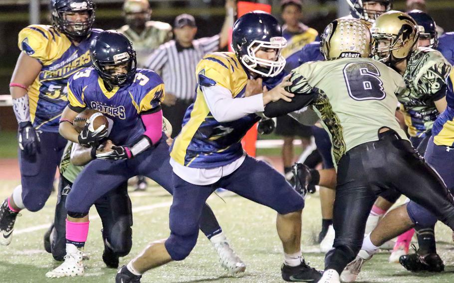 Guam High running back Julius Gaduang gets an escort from teammate Nick Keefe against Tiyan.