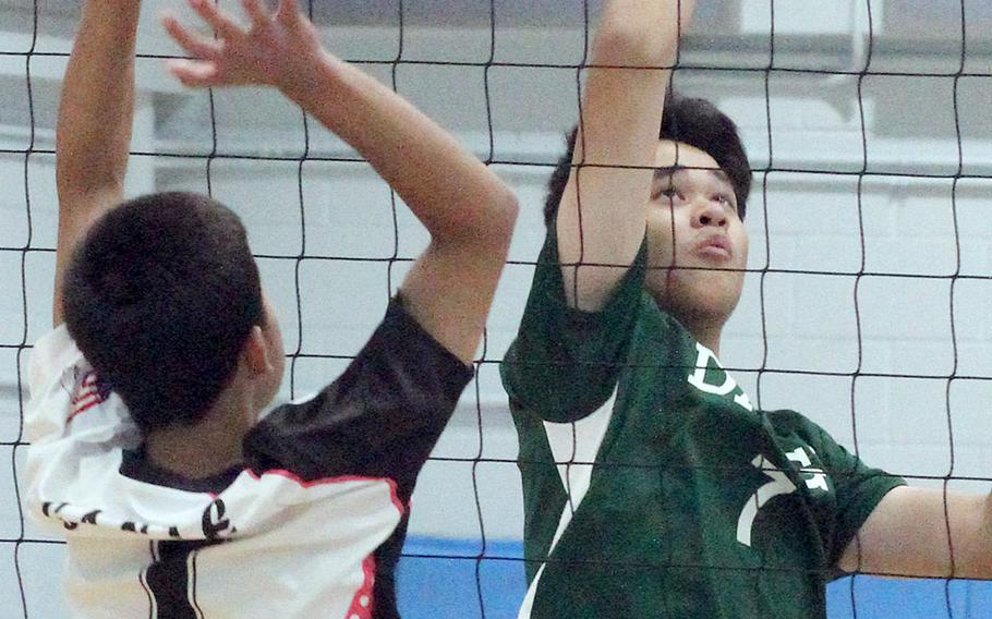 Daegu's Angus Delaney sends the ball past Osan's Jade Gante during Saturday's Korea boys volleyball match. The Warriors won in straight sets.