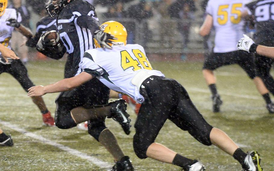 Zama running back Josh Reilly gets wrapped up by Robert D. Edgren defender Alexander Lavaux.