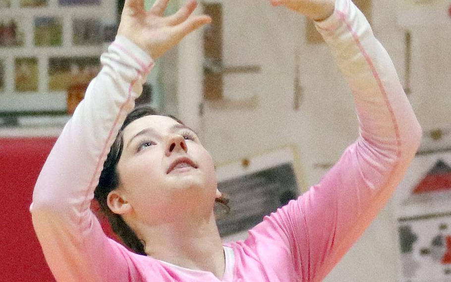 Nile C. Kinnick's Charlize Uptegrove sets against Christian Academy Japan during Tuesday's Kanto Plain volleyball match, won by the Red Devils in four sets.