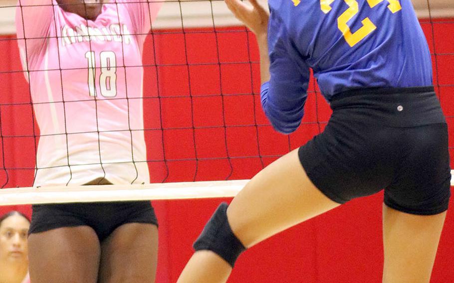 Nile C. Kinnick's Kiana Johnson goes up to block Christian Academy Japan's Mari Mosaku during Tuesday's Kanto Plain girls volleyball match, won by the Red Devils in four sets.