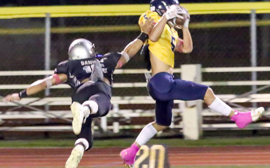 Guam High's Jalen Thach hauls in a catch against Simon Sanchez.