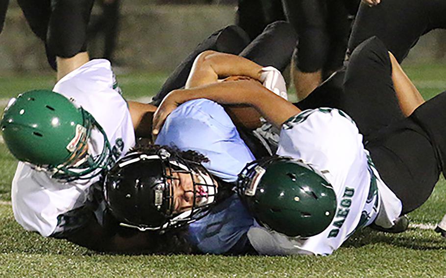 Osan's Israel Rouse is brought down by two Daegu defenders.