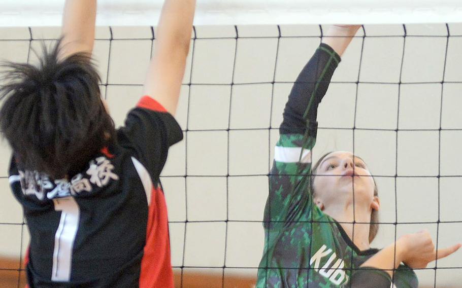 Kubasaki's Sophia Baumbach spikes past a Ginowan Kogyo defender during Saturday's matches in the 9th Okinawa-American district volleyball friendship festival at Kadena Air Base. The Dragons lost in two sets.