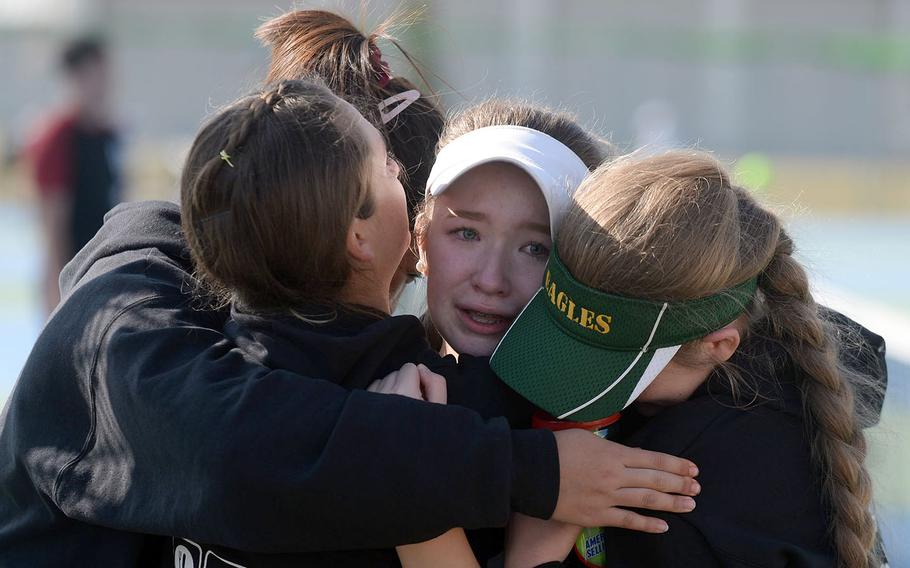 An emotional Jenna Mahoney gets a group hug from Robert D. Edgren teammates after winning the DODEA-Japan tournament girls singles A title for the second straight year.