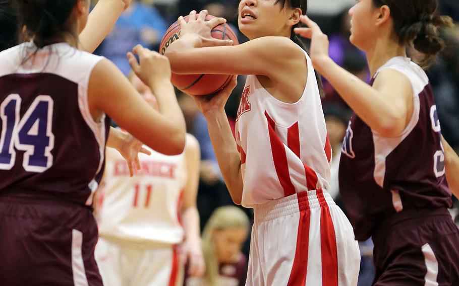 Kinnick's Amyka Jones looks to pass against Seisen defenders Lisa Purcell and Momone Ishibashi during Thursday's Kanto Plain girls basketball game. The Red Devils won 44-35 in overtime.