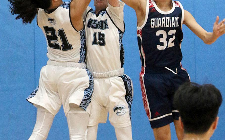 Osan's Ryan Klapmeyer and Israel Rouse battle Yongsan's Nathan Hong for a rebound during Wednesday's Korea Blue boys basketball game. The Guardians won 61-16.