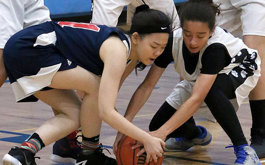 Gimme that ball! Yongsan's Isabelle Park and Osan's Dawn Kerlin battle for the ball during Wednesday's Korea Blue basketball game. The Guardians won 50-33.