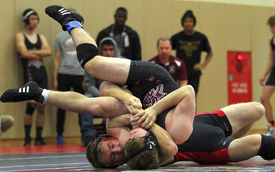 Nile C. Kinnick's Ethan Hamilton locks in a cradle on Matthew C. Perry's Parker Staley at 148 pounds during Saturday's DODEA-Japan dual meet tournament. Hamilton pinned Staley and the Red Devils won the dual meet 37-15.