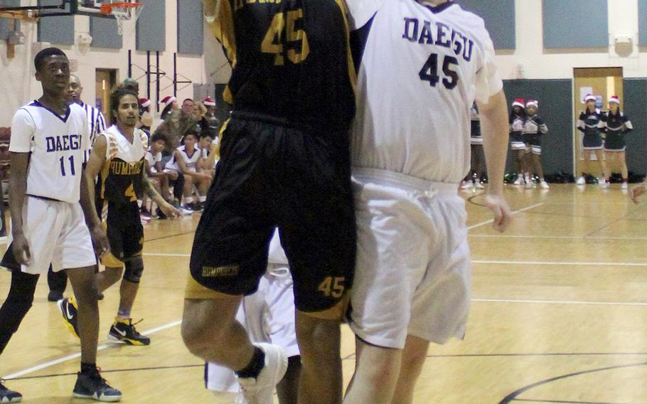 Humphreys' Collin Metcalf goes up to shot against Daegu's Chase Lamar during Wednesday's Korea Blue boys basketball game. The Blackhawks won 74-32.