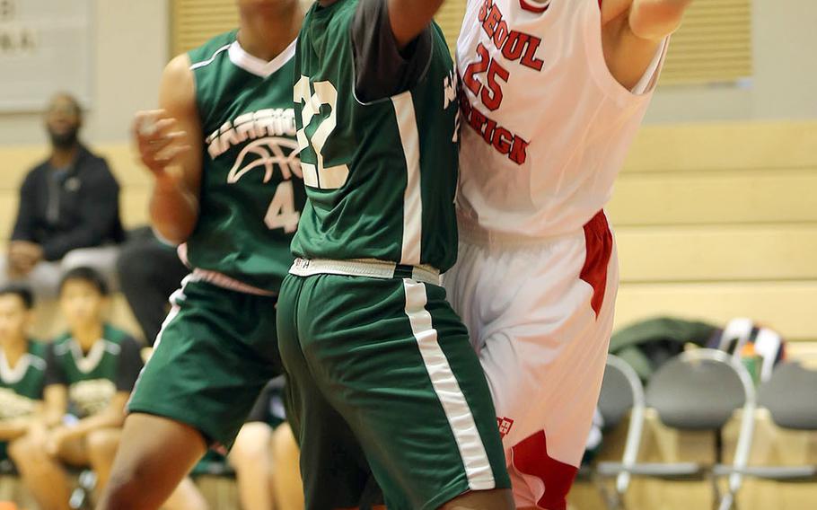 Seoul Foreign's Elliot Prest looks to pass against Daegu's Antwoine McCall during Friday's Korea Blue boys basketball game. The Crusaders won 54-47.