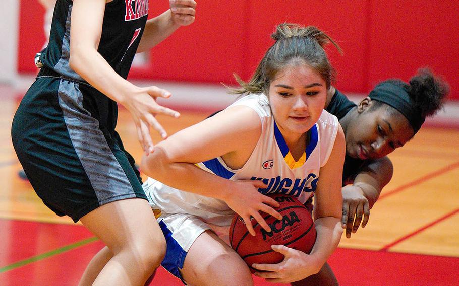 Christian Academy Japan's Rachel Nelson gets tied up by Nile C. Kinnick's Kiana Johnson and Amyka Jones during Thursday's Kanto Plain girls basketball game. The Knights won 46-28.