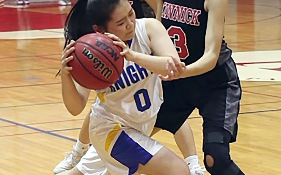 Christian Academy Japan's Hyeon Seo Kwon is hemmed in by Nile C. Kinnick's Ernestina Roberts during Thursday's Kanto Plain girls basketball game. The Knights won 46-28.