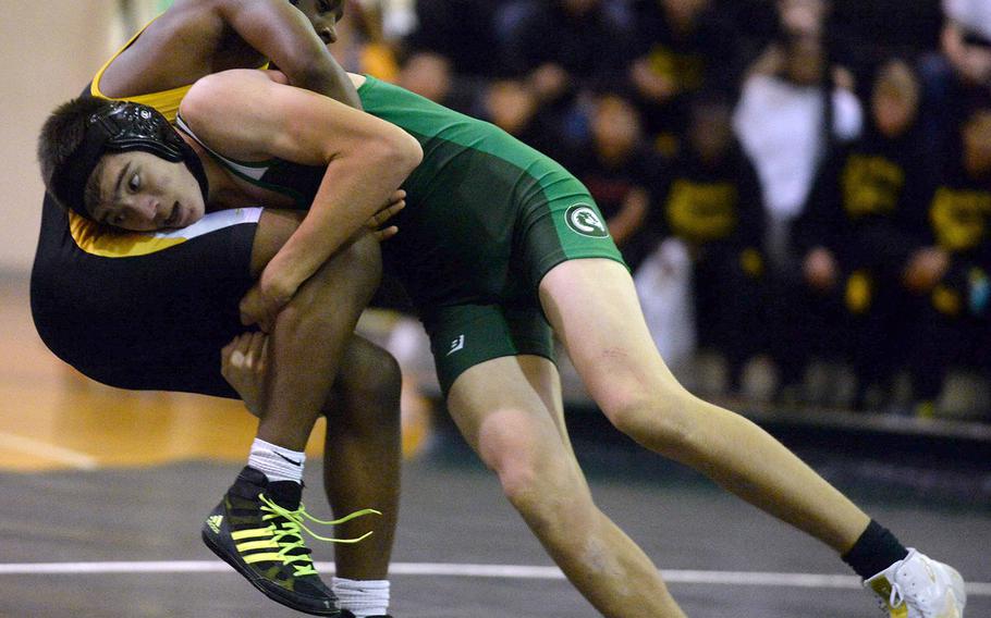 Kubasaki's Adrian Misenhimer lifts Kadena's Crisean Covington at 141 pounds during Wednesday's Okinawa wrestling dual meet. Covington won a 13-10 decision, but the Dragons won the meet 38-24.