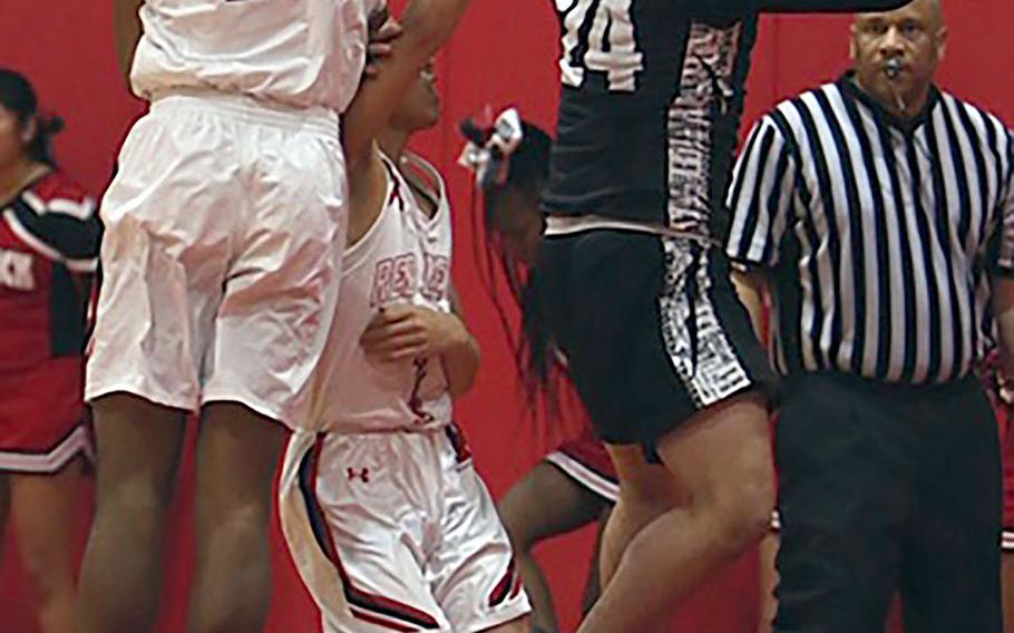 Nile C. Kinnick's Shawn Williams tries to block a shot by Zama's Kelby Shorter during Tuesday's DODEA-Japan/Kanto Plain boys basketball game. The Trojans won 64-61.