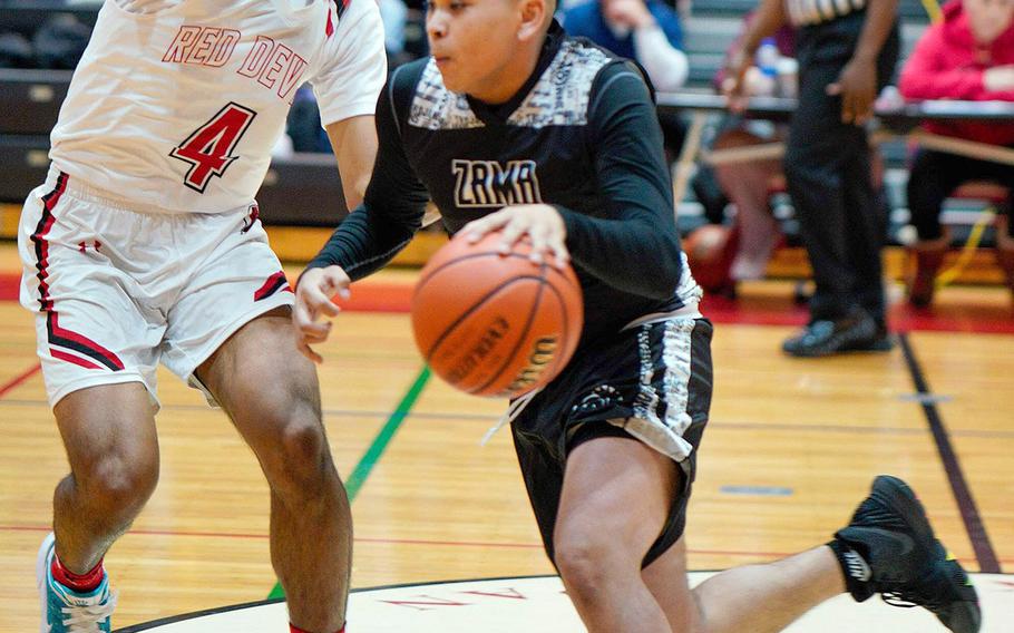 Zama's Kelby Shorter drives against Nile C. Kinnick's Darryl Williams during Tuesday's DODEA-Japan/Kanto Plain boys basketball game. The Trojans won 64-61.