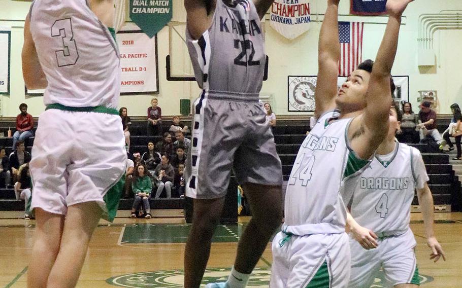 Kadena's John Emery shoots between Kubasaki defenders Sebastian Stone and Kiyon Smith during Friday's Okinawa boys basketball game. The Panthers won 65-31 and clinched the season series from the Dragons.