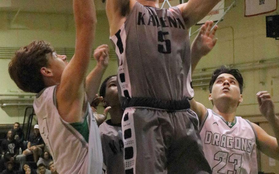 Kadena's Blake Dearborn skies for a rebound between Kubasaki's Sebastian Stone and Robbie Arroyo during Friday's Okinawa boys basketball game. The Panthers won 65-31 and clinched the season series from the Dragons.