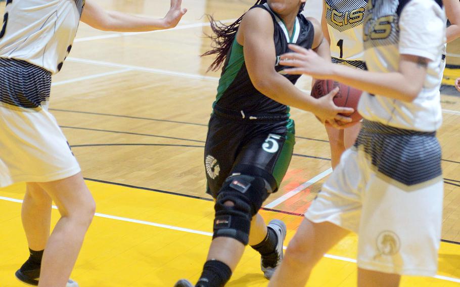 Daegu's Bethani Newbold drives between Taejon Christian's Katie Eggleston and Sylvia Yun during Friday's Korea Blue girls basketball game. The Warriors won 54-22.