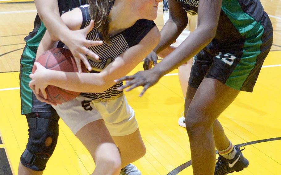 Taejon Christian's Katie Eggleston shields the ball from Daegu's Katrina Vasquez and Jya Van during Friday's Korea Blue girls basketball game. The Warriors won 54-22.