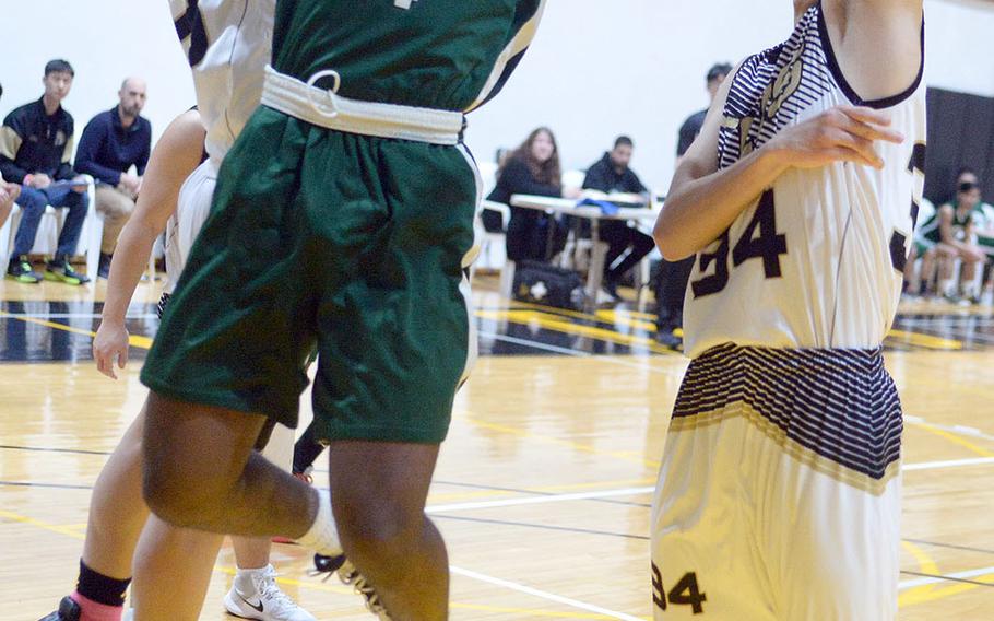 Daegu's Antwoine McCall shoots between Taejon Christian defenders during Friday's Korea Blue boys basketball game. The Dragons won 47-26.