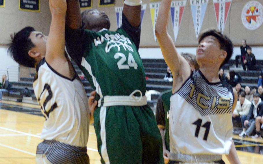 Daegu's Ziadee Barjolo grabs a rebound between Taejon Christian's Jaeson Pyeon and Josh Yun during Friday's Korea Blue boys basketball game. The Dragons won 47-26.