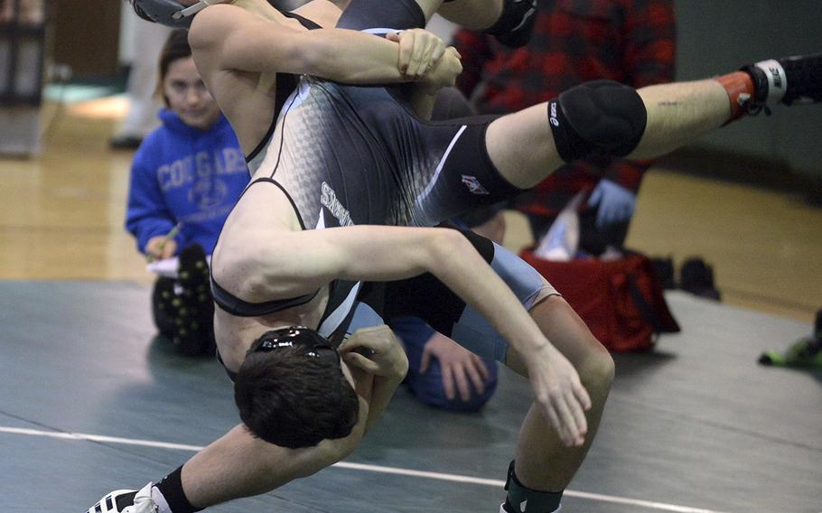 Osan's Toy Williams lifts Humphreys' Zack Downs at 141 pounds during Saturday's Daegu quad-meet. Williams won by technical fall 12-2.