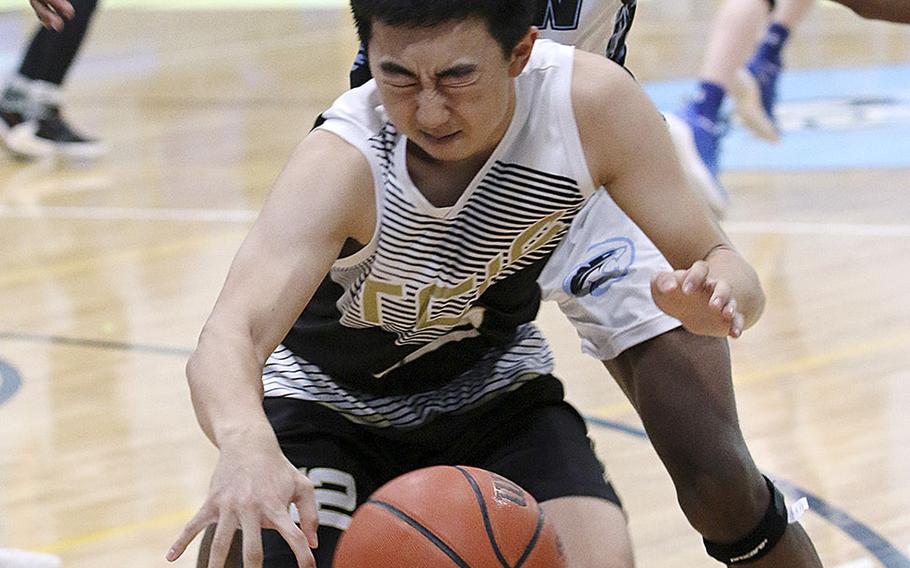 Taejon Christian International's Jaeson Pyeon is hemmed in by Osan's Bryson Goldsmith during Saturday's Korea Blue boys basketball game. The Cougars won their first game in six tries 67-44 over the Dragons.