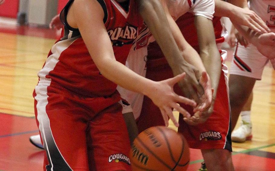 Nile C. Kinnick's Shawn Williams and St. Maur's Luigi Barrios battle for the ball during Wednesday's Kanto Plain boys basketball game. The Red Devils won 86-27.