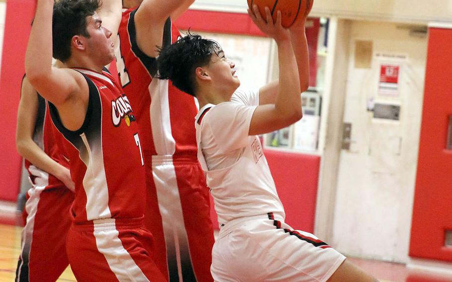Nile C. Kinnick's Tristan Venturina drives for a shot against St. Maur defenders during Wednesday's Kanto Plain boys basketball game. The Red Devils won 86-27.